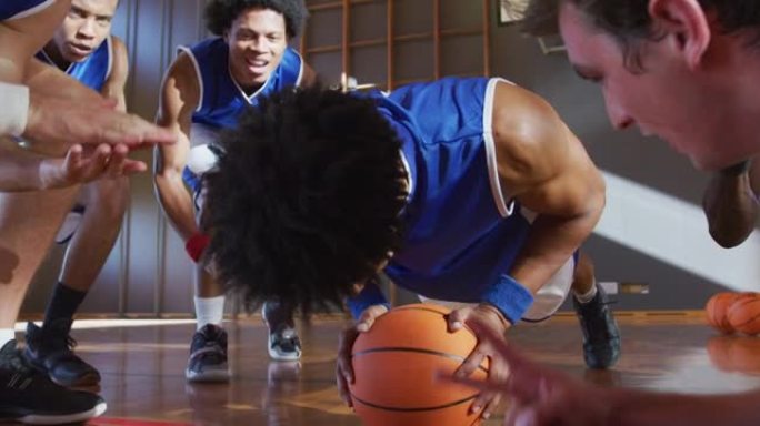 多元化的男子篮球队穿着蓝色运动服并做俯卧撑