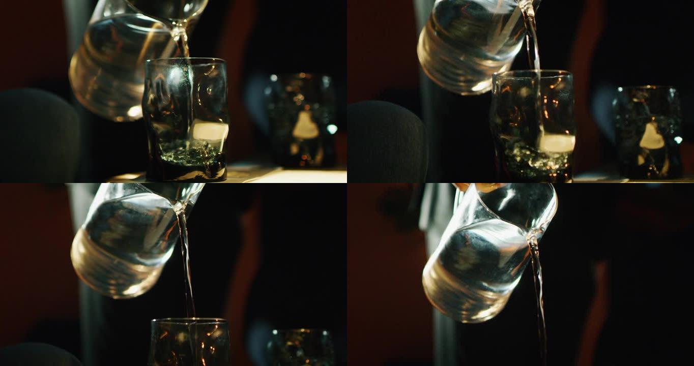 专业调酒师的特写镜头是在酒吧或迪斯科俱乐部为顾客提供含冰块的酒精鸡尾酒。