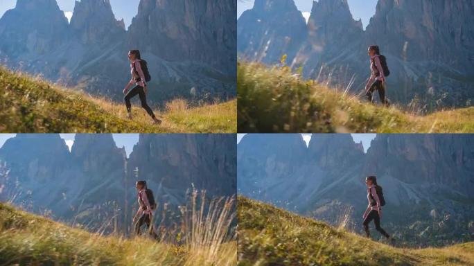 健康的女运动员保持健康的生活方式，在岩石小径上徒步旅行，周围风景迷人