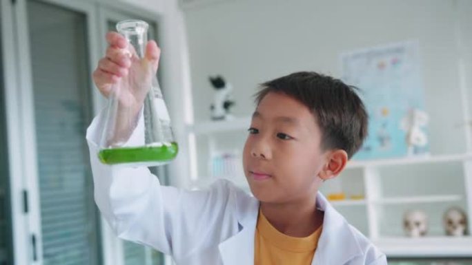 小学生在烧杯中混合化学物质。学校的STEM教育。