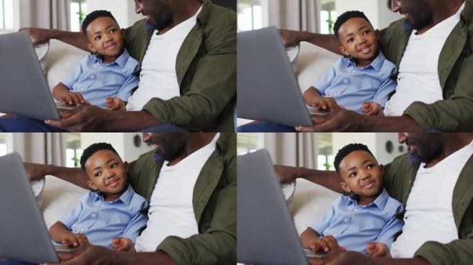 非裔美国人父子一起使用笔记本电脑