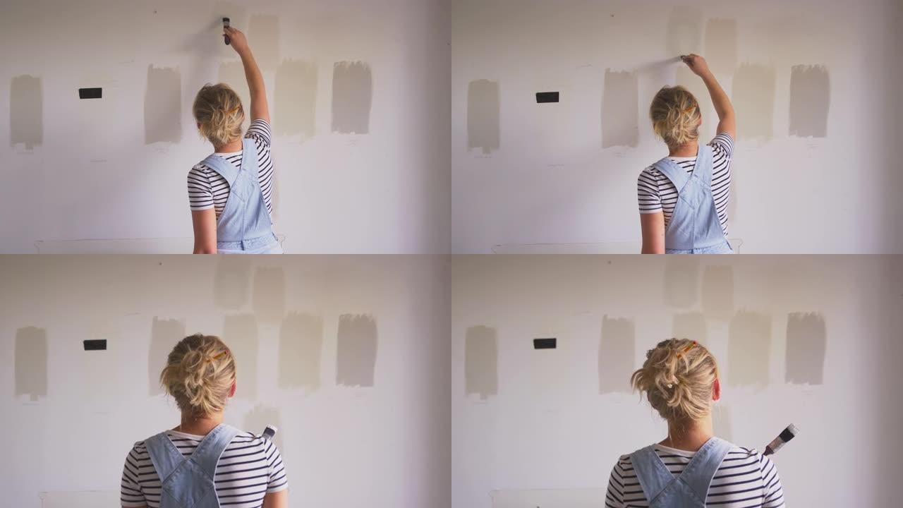 房屋油漆测试仪中女性装饰室的后视图在墙上油漆色条