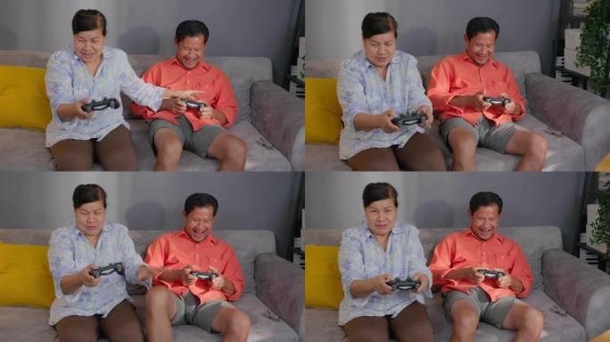 亚洲祖母和祖父在家里的客厅玩电子游戏。