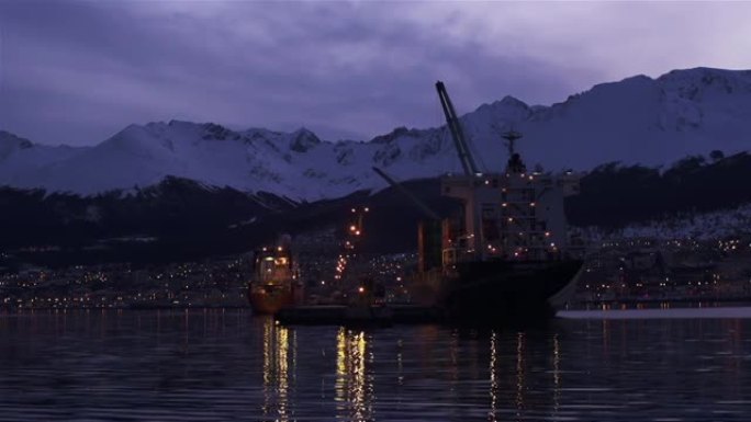 日落时抵达乌斯怀亚港，从阿根廷巴塔哥尼亚火地岛比格尔海峡的一艘船上看到。4k分辨率。