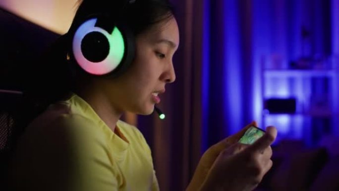 玩家戴耳机比赛用智能手机在线玩视频游戏
