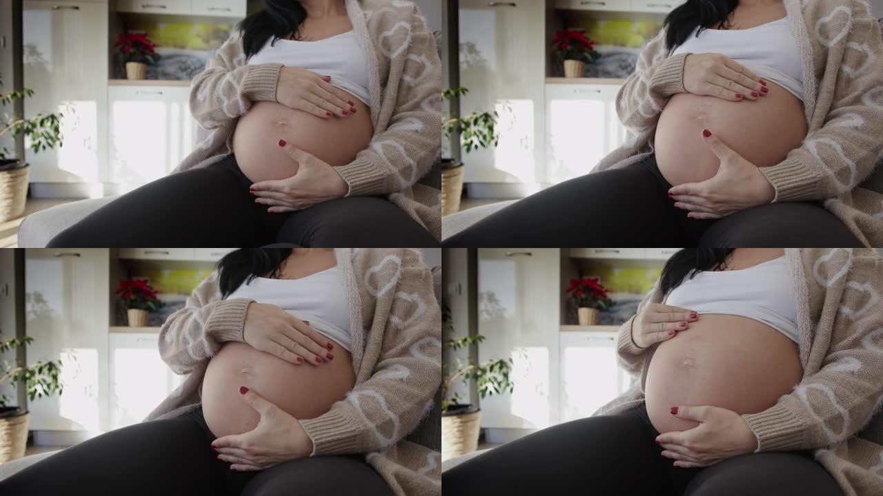 怀孕后期的SLO MO年轻女子爱抚她的肚子