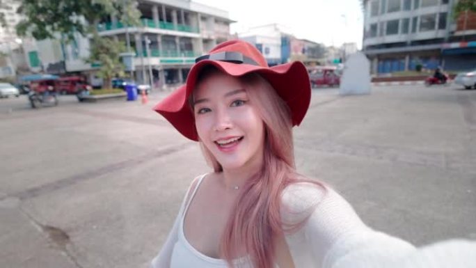 旅行者美丽的亚洲女人用手机vlogging
