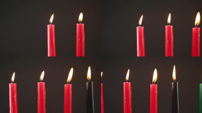 黑色背景下的万圣节绿色，黑色和红色点燃蜡烛的组成