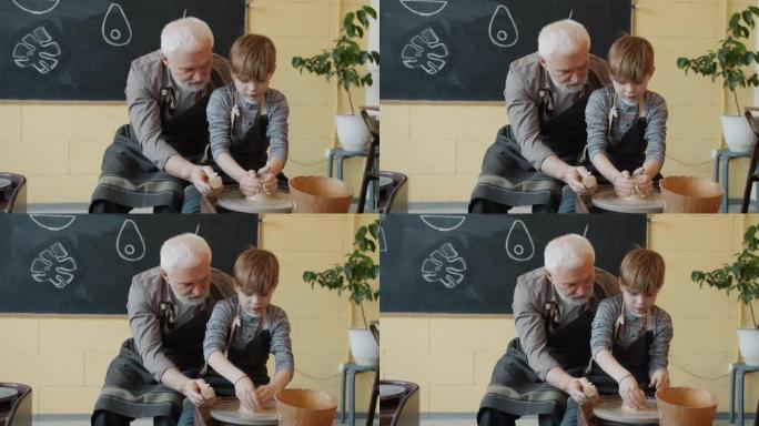 祖父和孙子在工作室的投掷轮上用粘土制作锅