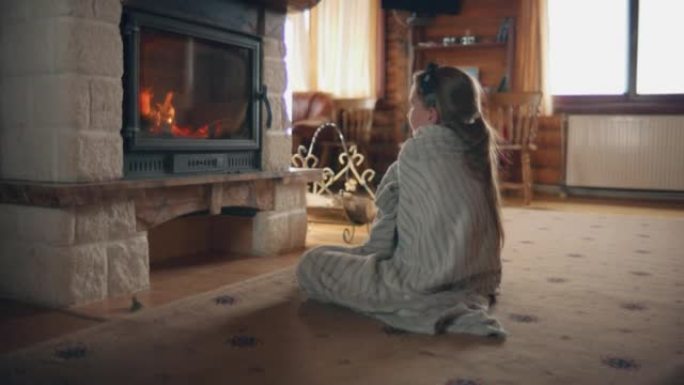 年轻女孩坐在壁炉旁