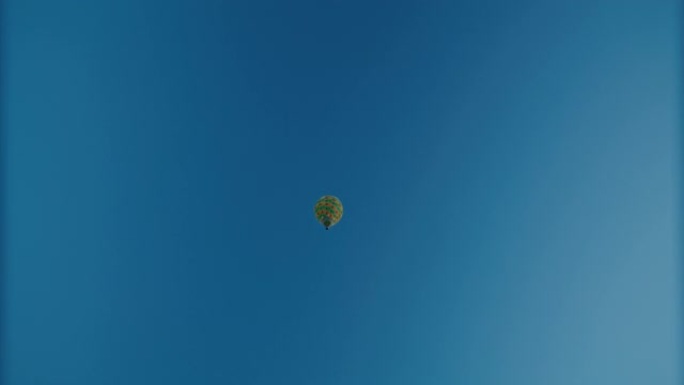 方格热气球漂浮在阳光明媚，宁静的蓝天中