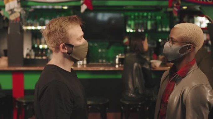 戴着面具的男人在酒吧互相问候