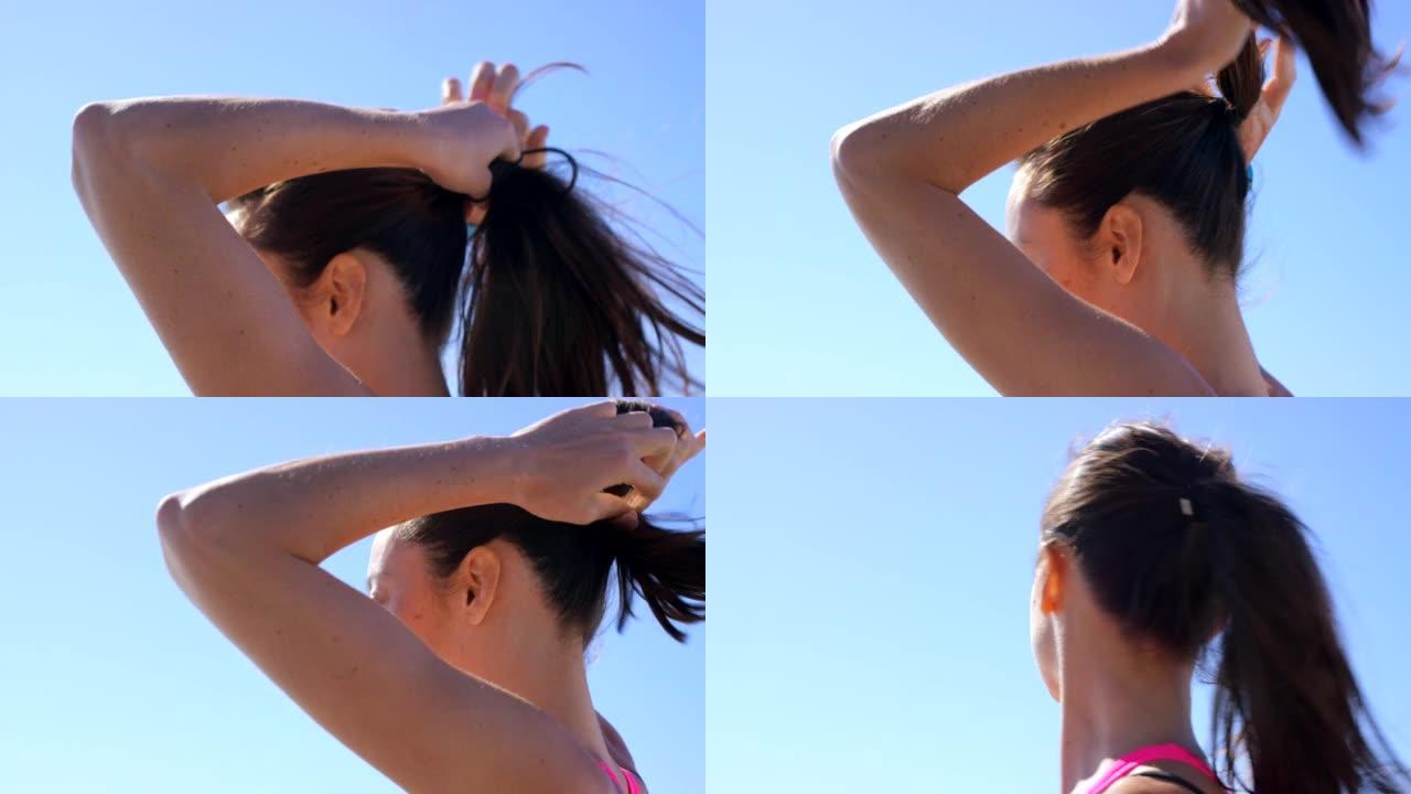 4k视频片段，一名妇女在奔跑前将头发扎成马尾辫