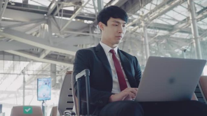 在机场使用笔记本电脑的商人。