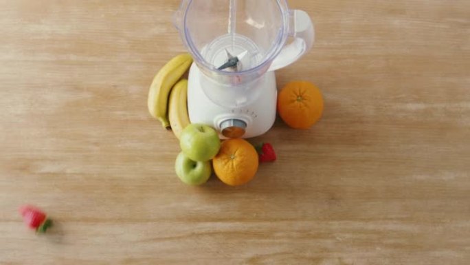 新鲜草莓、香蕉、青苹果、浆果、坚果和橙子的俯视图，以及制作健康奶昔健康节食和营养、碱性、素食概念的搅