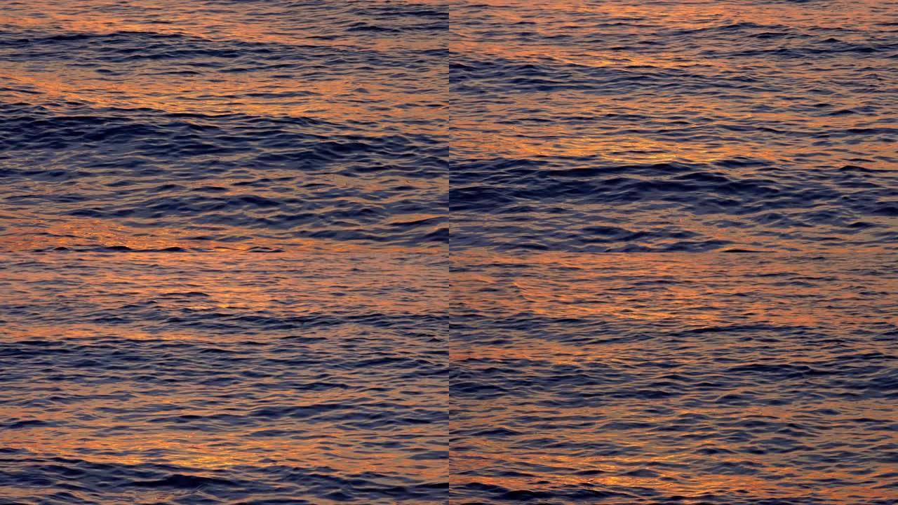 海浪表面被夕阳的光线涂成金色。蓝色和金色海浪的慢动作镜头。放松和舒适的氛围概念。慢动作镜头