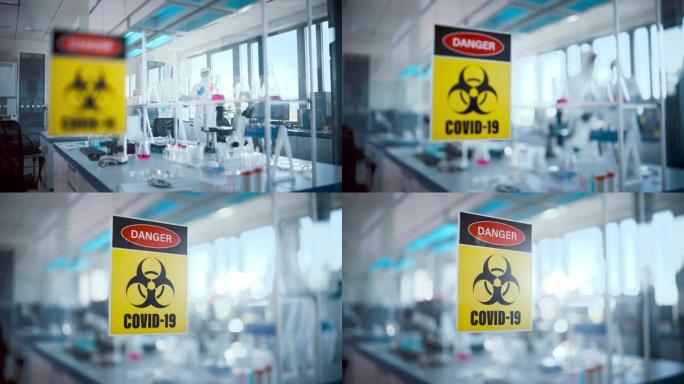 病毒学和医学研究实验室玻璃门上的危险新型冠状病毒肺炎标志: 戴着口罩和工作服的科学家团队致力于新型冠
