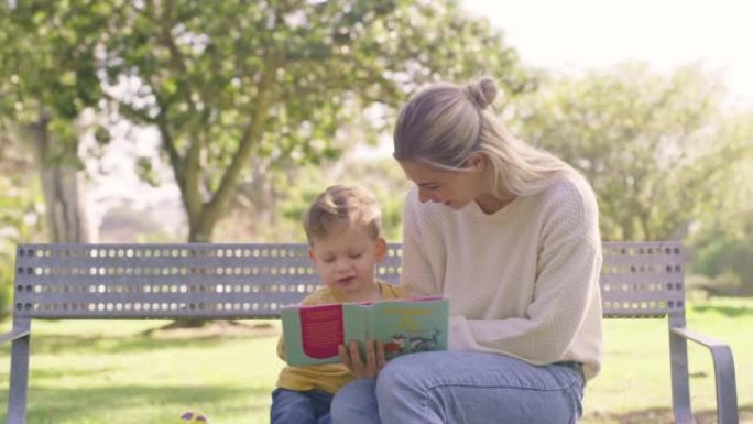 母亲和她的孩子在公园里读书，在夏天一起教育，学习和度过愉快的周末。妈妈坐在大自然的长凳上，给一个快乐