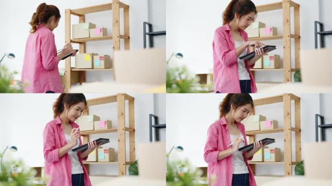 年轻的亚洲企业家女商人在库存上检查产品采购订单，并保存到家庭办公室的平板电脑工作。