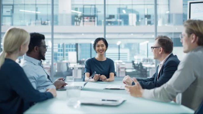 公司会议室: 自信的亚洲女性执行董事向董事会成员和投资者报告公司实现创纪录的年度收入业绩。