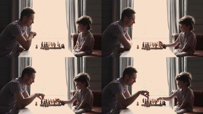 快乐的年轻人和聪明的小男孩下棋。