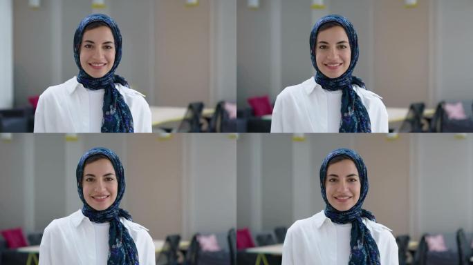 一名戴着头巾的中东妇女的肖像站在她的办公室里