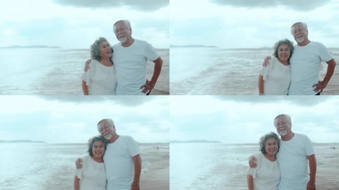 高年级可爱的夫妇沿着海滩散步