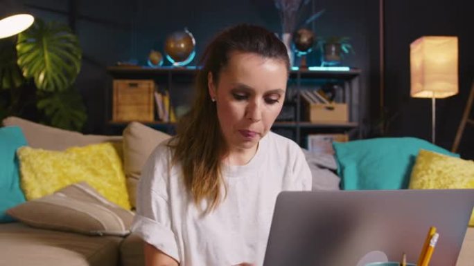 在网上购买美丽快乐的年轻兴奋的高加索博客女人使用笔记本电脑在家明亮的客厅工作