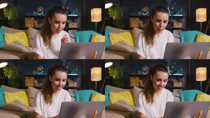 在网上购买美丽快乐的年轻兴奋的高加索博客女人使用笔记本电脑在家明亮的客厅工作
