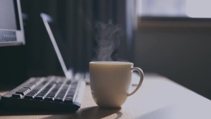 木桌上的热咖啡和电脑