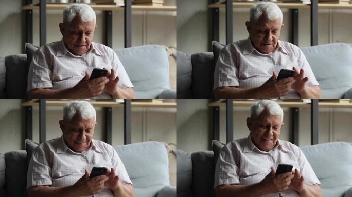 微笑的中年男子在现代手机上使用移动应用程序