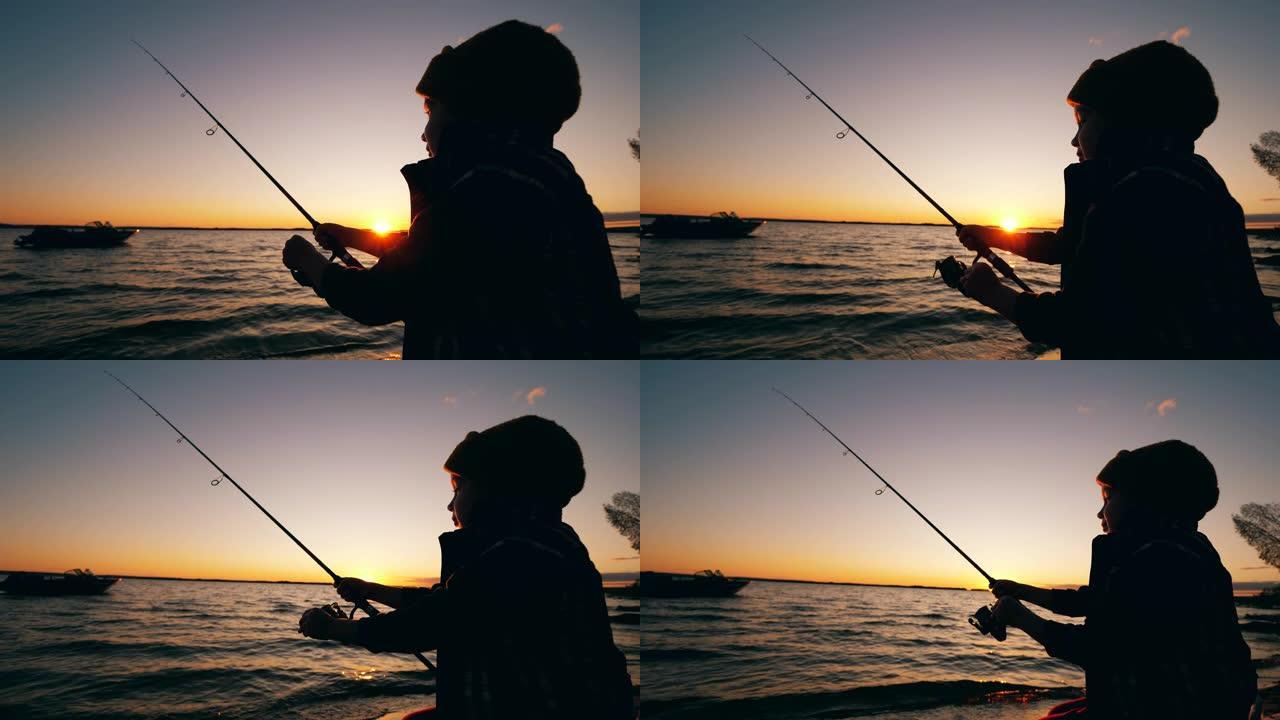 日落时，一个孩子在湖中用杆子钓鱼