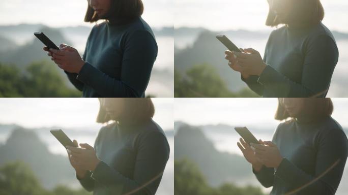 女旅行者在山区自然国家公园拍照并使用智能手机通过电话scenic