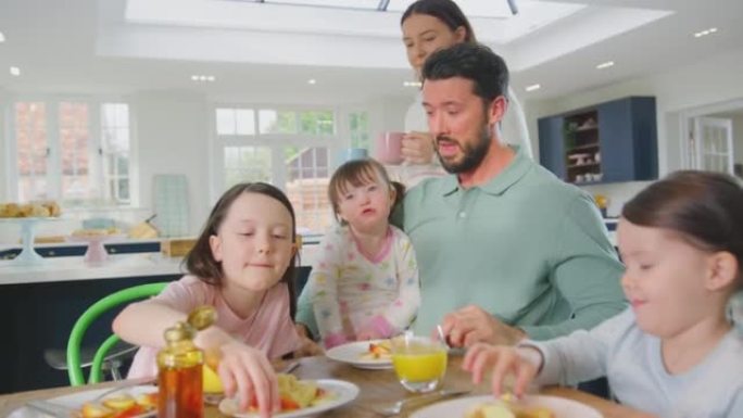唐氏综合症女儿的家庭坐在家里吃早餐