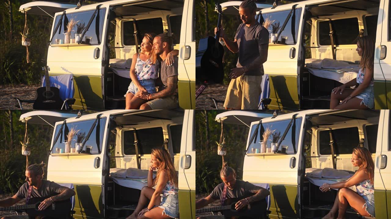 夫妇坐在白色露营面包车的侧面，男人弹吉他，享受日落