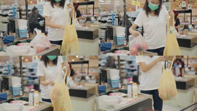亚洲妇女在无废物商店包装可重复使用的购物袋