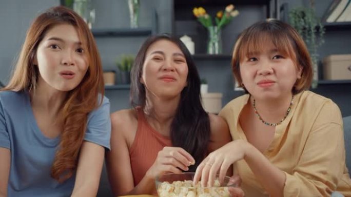 迷人的亚洲可爱女组合积极快乐快乐与休闲玩得开心，在家客厅沙发上看在线电影娱乐。生活方式活动检疫概念。