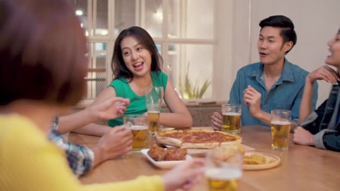 团体快乐的亚洲朋友在家里玩得开心，享受啤酒，朋友用餐和派对概念