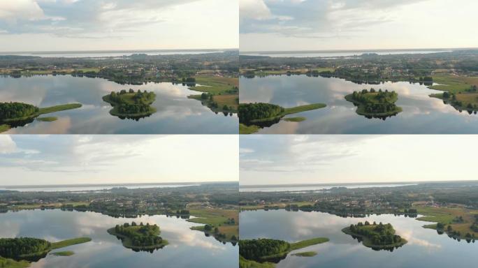 史诗般的空中背景，中间是平静的大型日出湖泊，树木和风景如画的小镇。白俄罗斯布拉斯拉夫。