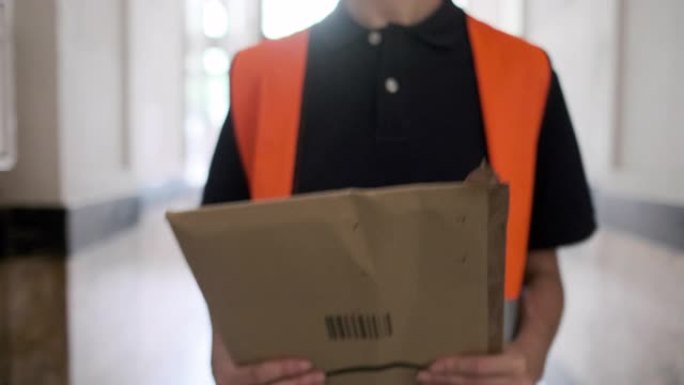 邮政工作人员将邮件放入公寓楼邮箱