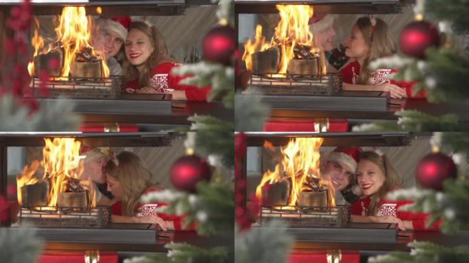 可爱的情侣在看壁炉里燃烧的火时表现出爱意