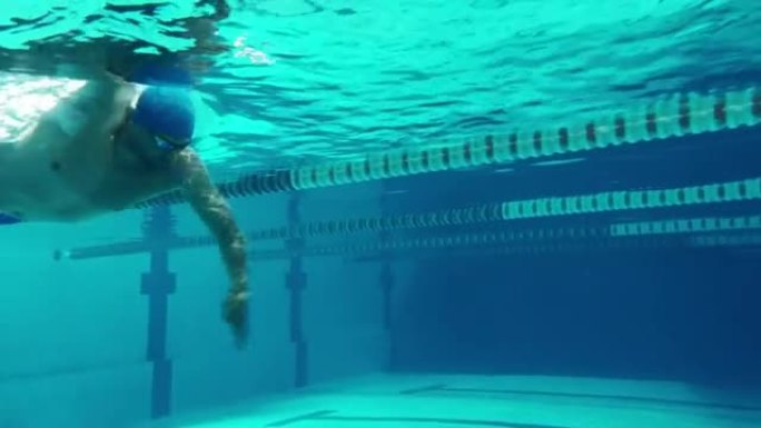 水下射击: 适合肌肉发达的游泳者在游泳池里跑圈。英俊的职业运动员以极快的速度游泳-准备创造世界冠军纪