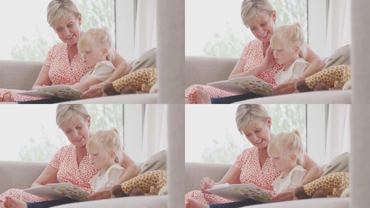 祖母和孙女坐在沙发上一起看书