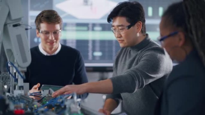 与亚洲同学和黑人老师一起在项目中工作时，用平板电脑指着机器人手的男学生。现代技术、科学和发展理念