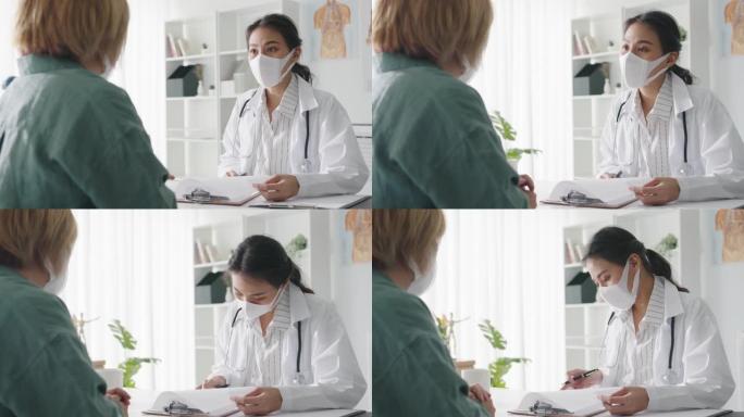 年轻的亚洲女士医生戴防护口罩使用剪贴板正在与医院的女孩患者讨论结果或症状发表重大新闻谈话。