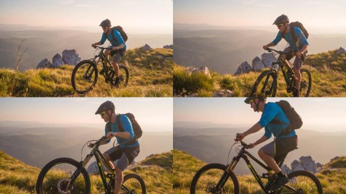 在大自然的户外运动，山地自行车上坡，日落时被绿色的草地和山脉包围