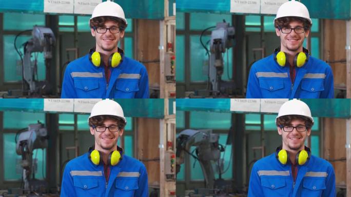 肖像27岁的白人年轻人他是工程师微笑着看着相机，同时在工厂工业的背景下工作控制自动化机器人。美国蓝领