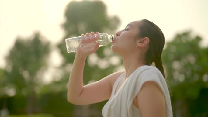 运动女子在日落高强度锻炼后喝水补水