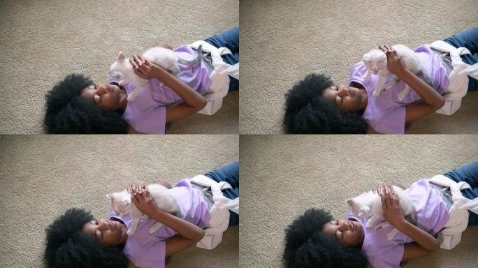躺在地板上玩小猫的女孩