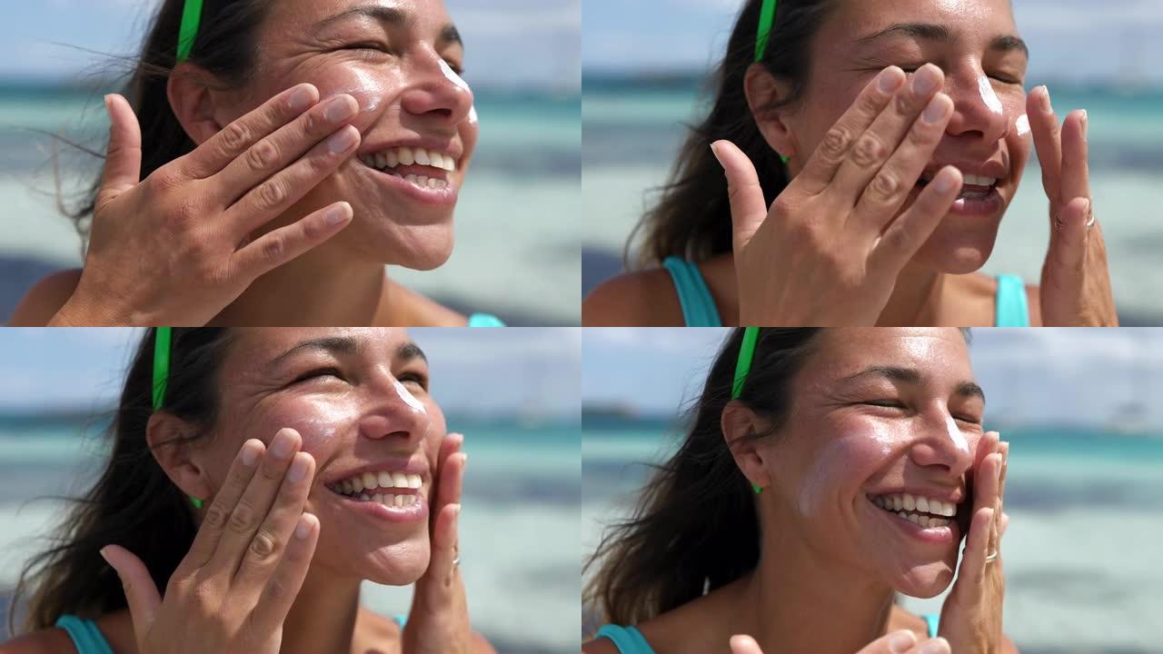 一个年轻漂亮的女人涂防晒霜在沙滩上微笑的肖像。快乐的女性安全晒黑，在夏天享受假期的同时保护皮肤免受阳